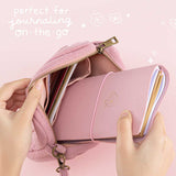 Tsuki ‘Sakura Journey’ Limited Edition Travel Notebook held in hands in Tsuki ‘Sakura Journey’ Travel Pouch in pink background