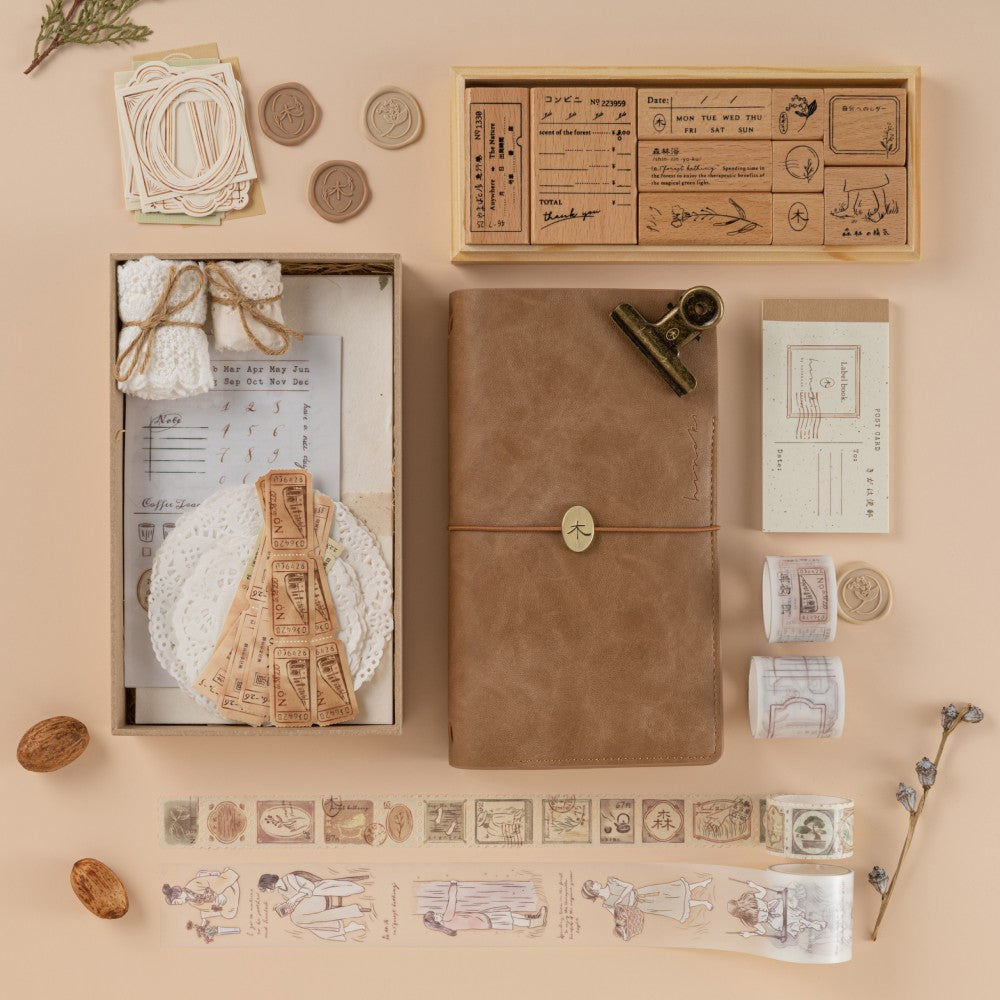 Flatlay of scrapbook set, travel notebook, washi tapees and stamps