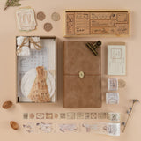 Flatlay of scrapbook set, travel notebook, washi tapees and stamps