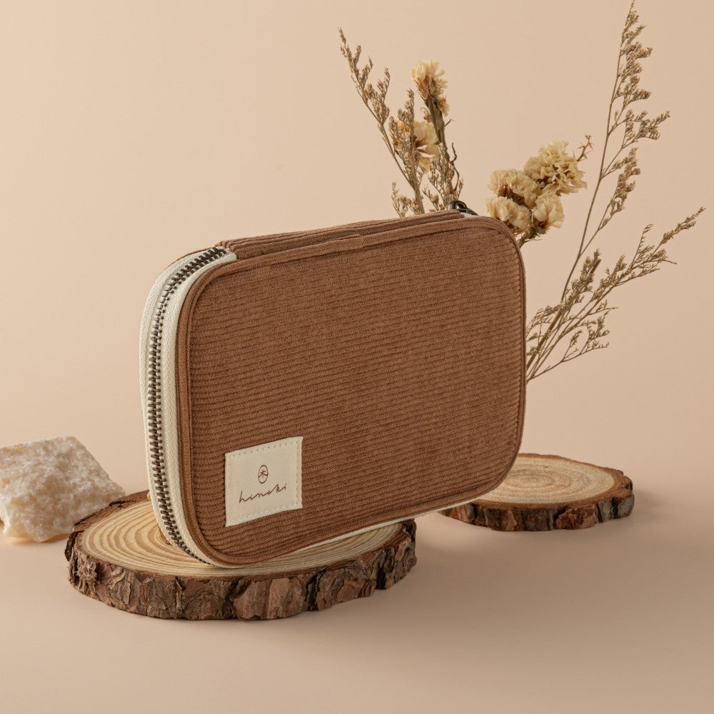 Corduroy pouch on wooden slice with dried flowers