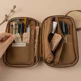 Opened brown pencil case with pens, pencils, stamps, eraser and train tickets inside