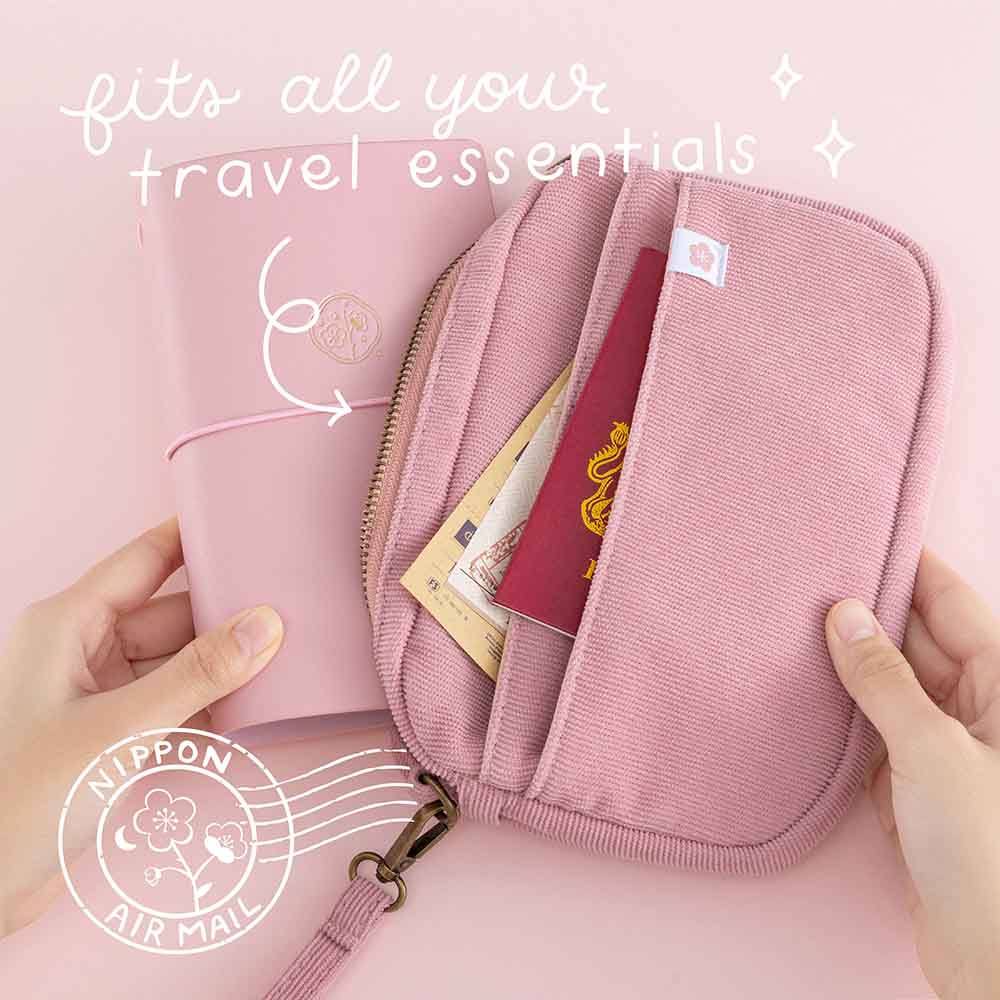 Tsuki ‘Sakura Journey’ Travel Pouch which fits all your travel essentials and Tsuki ‘Sakura Journey’ Limited Edition Travel Journal held in hands in pink background