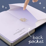 Open back page pocket of Tsuki ‘Winter Journey’ Limited Edition Bullet Journal held in hand with free bookmark gift on navy background