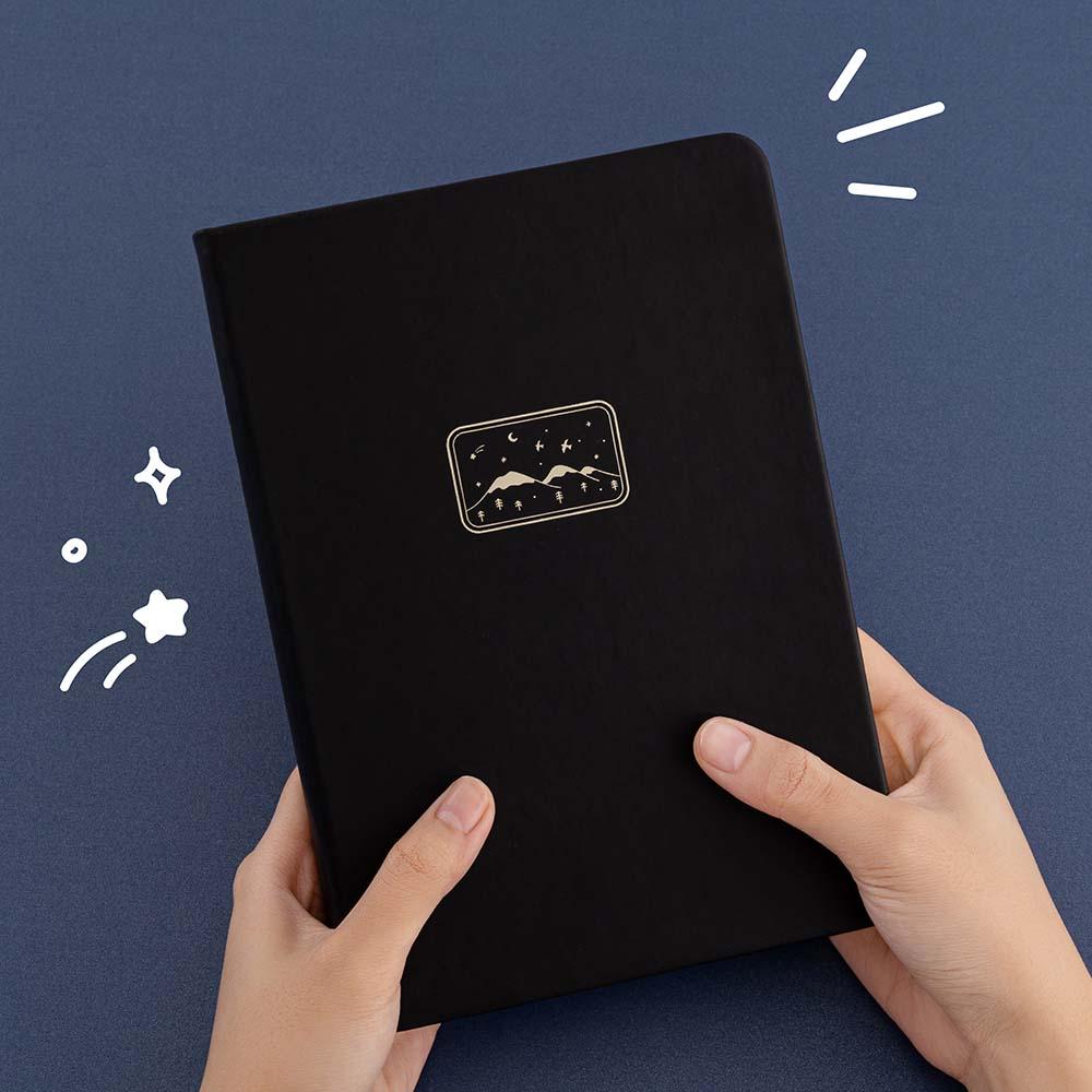 Tsuki ‘Winter Journey’ Limited Edition Bullet Journal held in hands in navy background