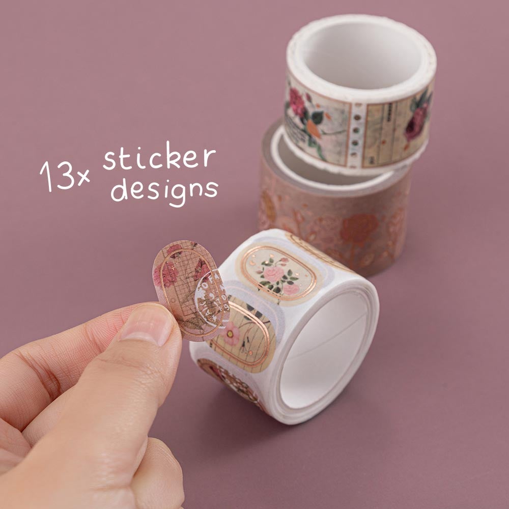 Tsuki ‘Vintage Rose’ Washi Sticker Tape with thirteen sticker designs held in hands in mauve background