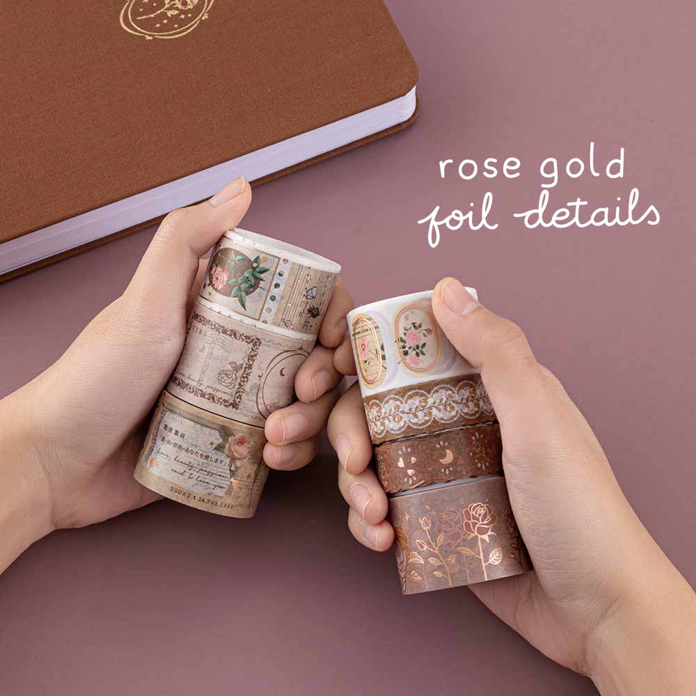 Tsuki ‘Vintage Rose’ Washi Tape Set with rose gold foil details held in hands with Tsuki ‘Vintage Rose’ Limited Edition Bullet Journal on mauve background