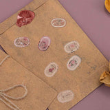 Tsuki ‘Vintage Rose’ Washi Sticker Tape on kraft paper letters with dried rose petals on mauve background