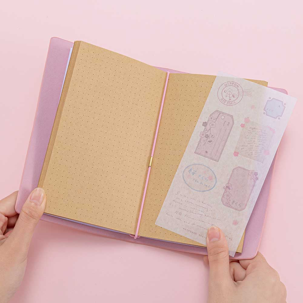 Open Tsuki ‘Sakura Journey’ Limited Edition Travel Notebook held in hands on pink background