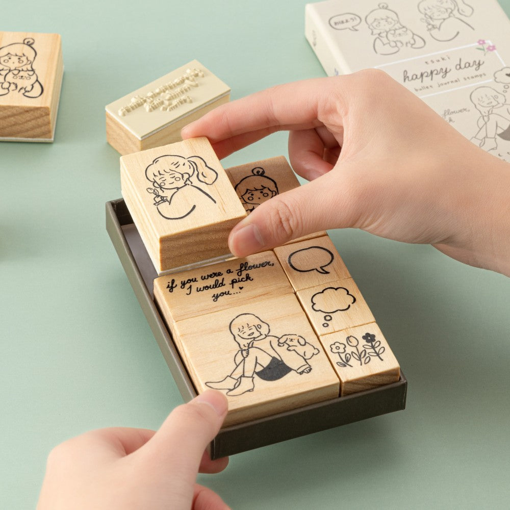 Hand taking out girl stamp from Tsuki Happy Day bullet journal stamp set box