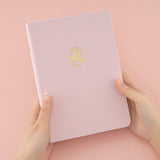 Hands holding Tsuki Sakura Breeze limited edition bullet journal by Notebook Therapy
