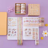 Tsuki Bunny Blush Washi Tape Set designed with Blossom Bujo rolled out on open bullet journal with Tsuki Honey Butter ‘Bunny Blush’ Limited Edition Bullet Journal with felt flowers on lilac background