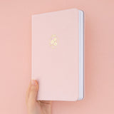 Hand holding Tsuki Sakura Breeze limited edition bullet journal by Notebook Therapy at an angle