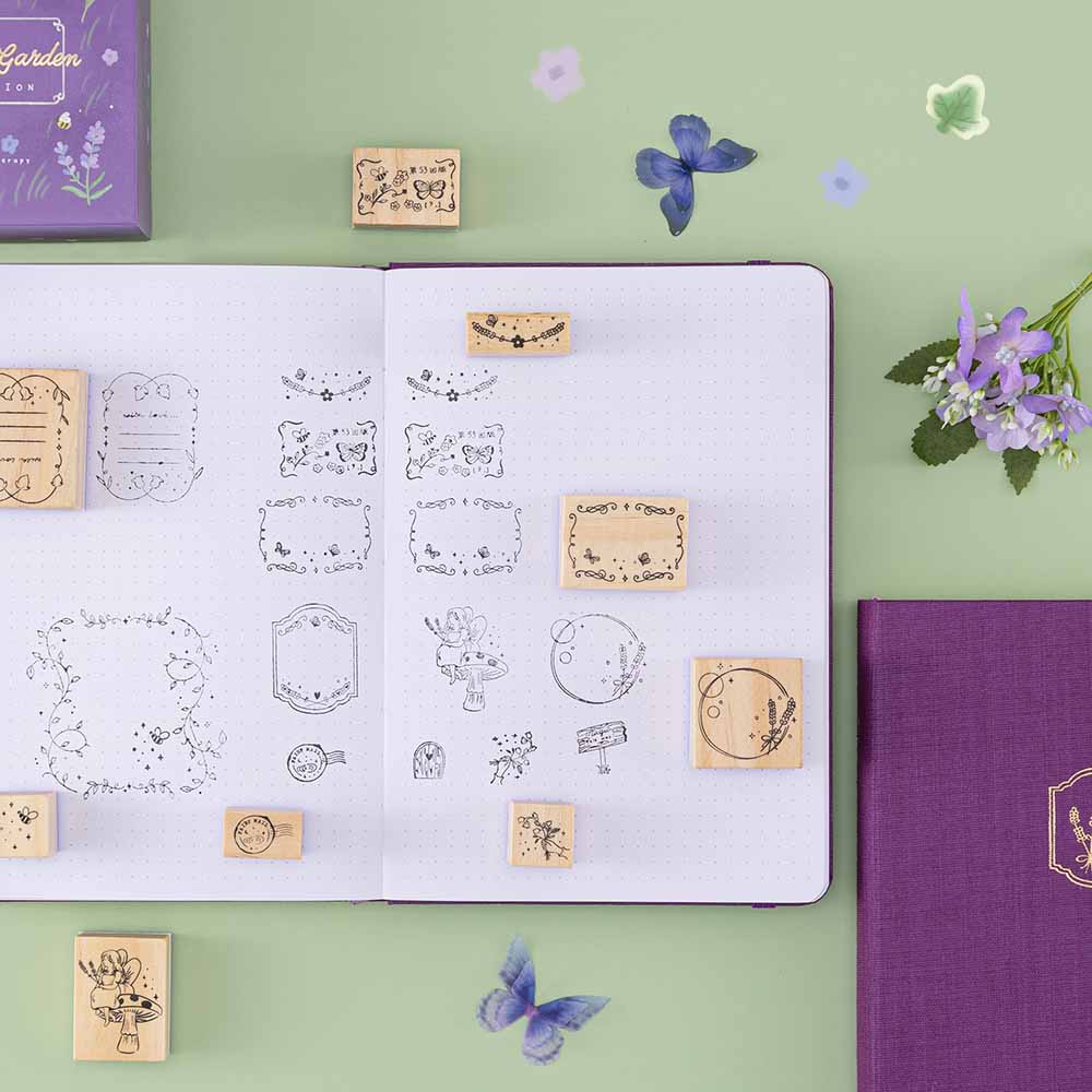 Tsuki ‘Enchanted Garden’ Stamp Set  on open flat notebook with on sage green background with butterflies decoration