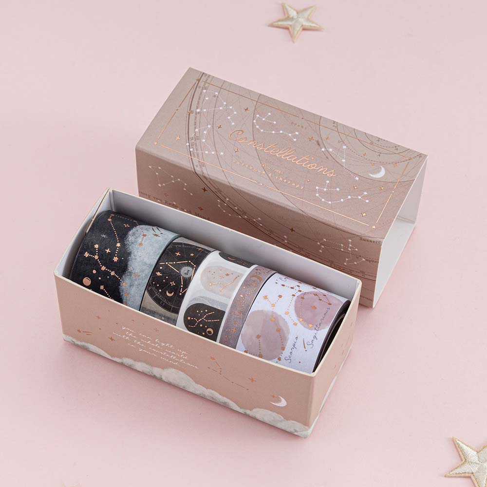 Box of constellations washi tape set opened on top of a pink background