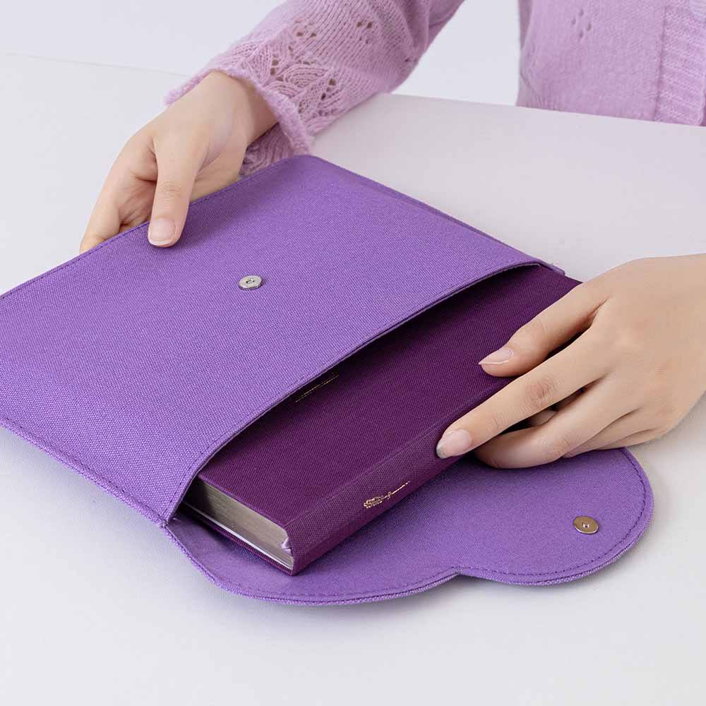 Hand putting a notebook inside the notebook pouch