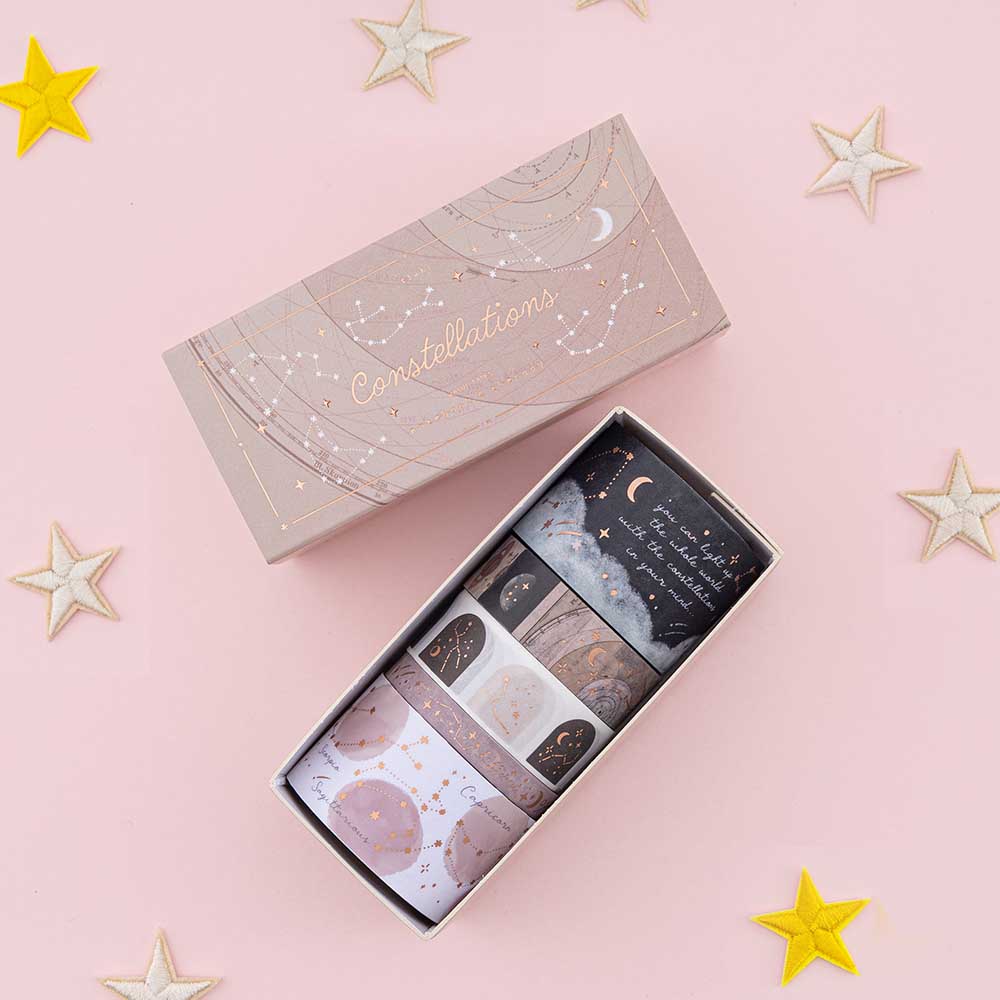 Tsuki Constellations Washi Tape Set by Notebook Therapy on pink background with star-shaped decorations around the open box