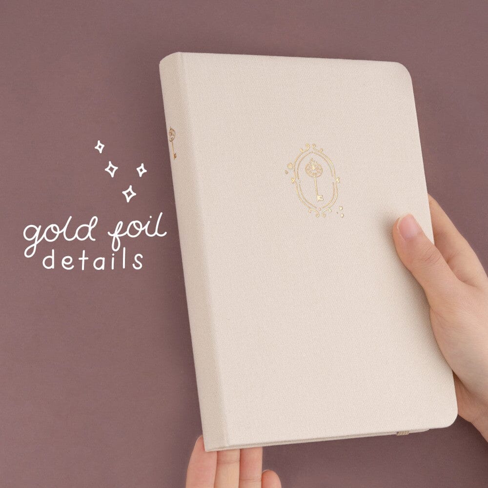 Gold foil details on cream linen notebook cover