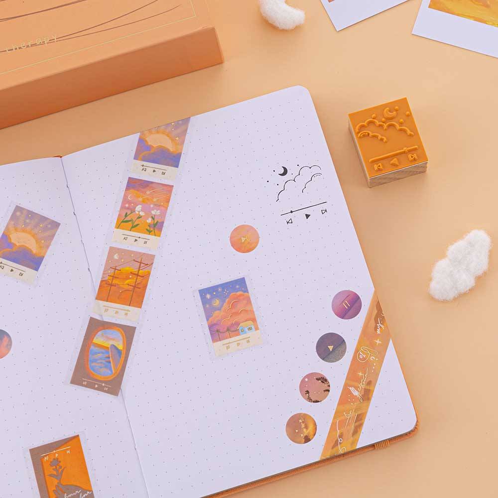 Washi tapes and playlist stamp on dotted bullet journal on orange background