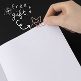 Star paperclip at the edge of dotted bullet journal page with white lettering that says “free gift”