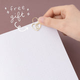 Hand putting heart shaped padlock paperclip on page with text “free gift”