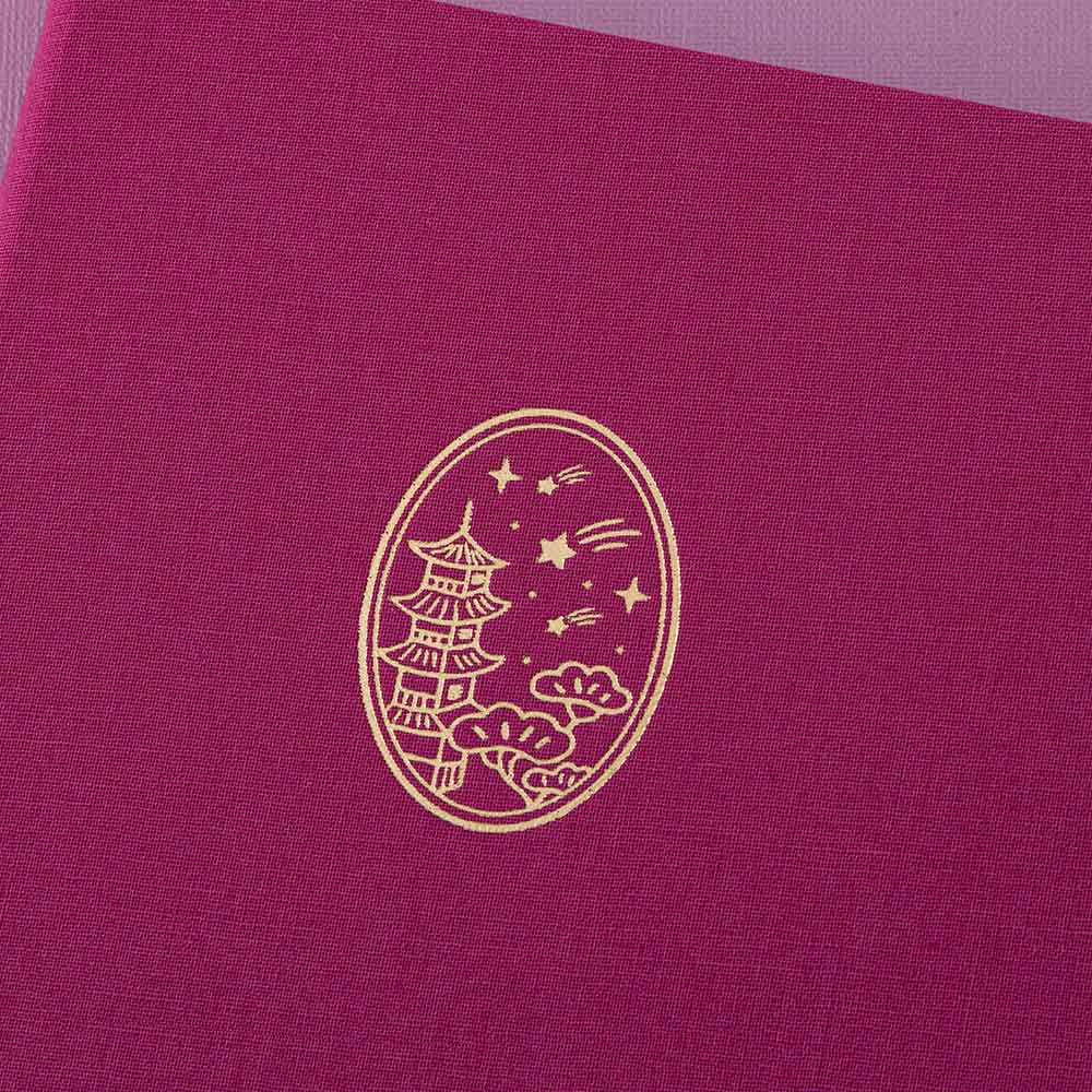Close-up of the gold foil details on the pink linen notebook