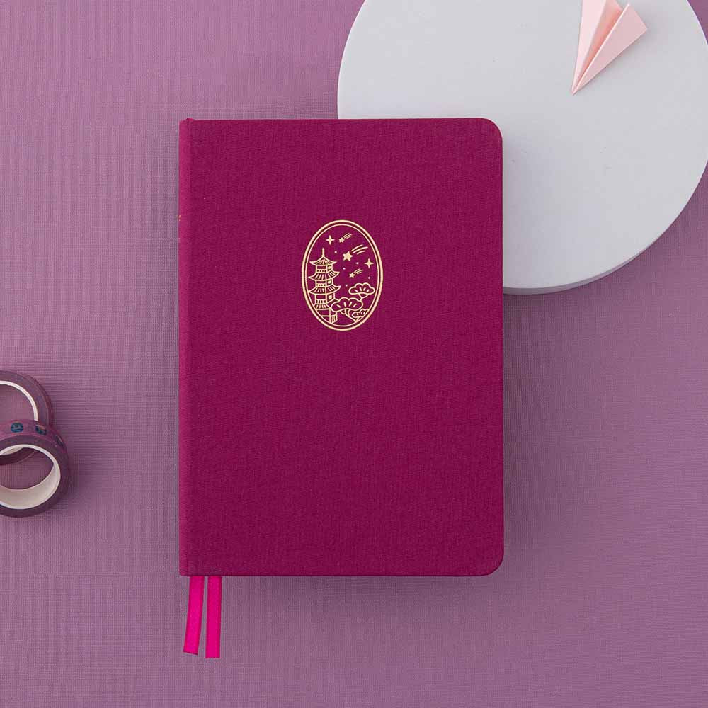 Flatlay of Tsuki Kyoto bullet journal in fuchsia pink with gold details against a pink backgroundFlatlay of Tsuki Kyoto bullet journal in fuchsia pink with gold details against a pink background