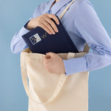 Model carrying a tote bag and putting Cloud Dreaamland notebook pouch inside the tote bag