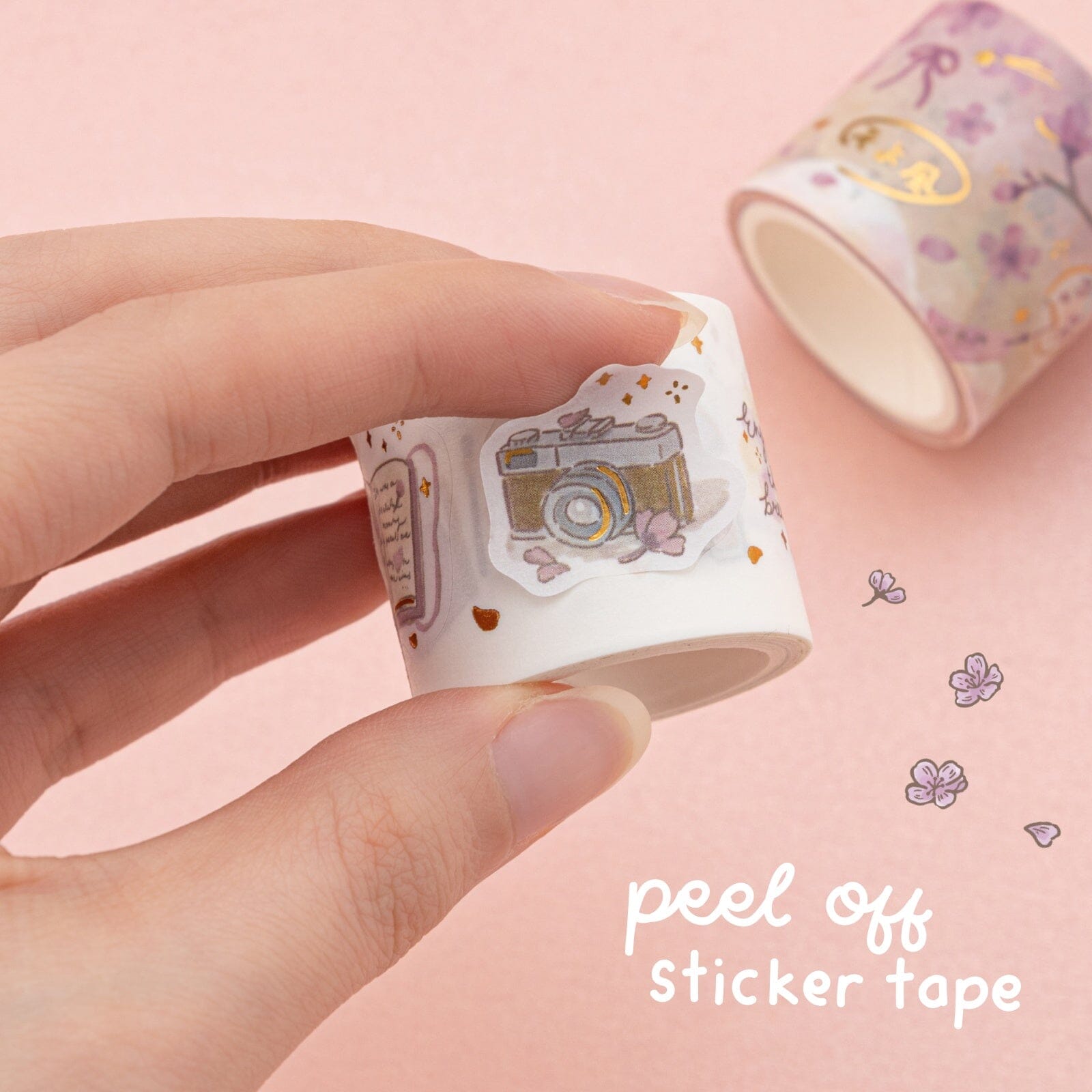 Peel of sticker tape close up showing illustration of vintage camer with sakura illustrations