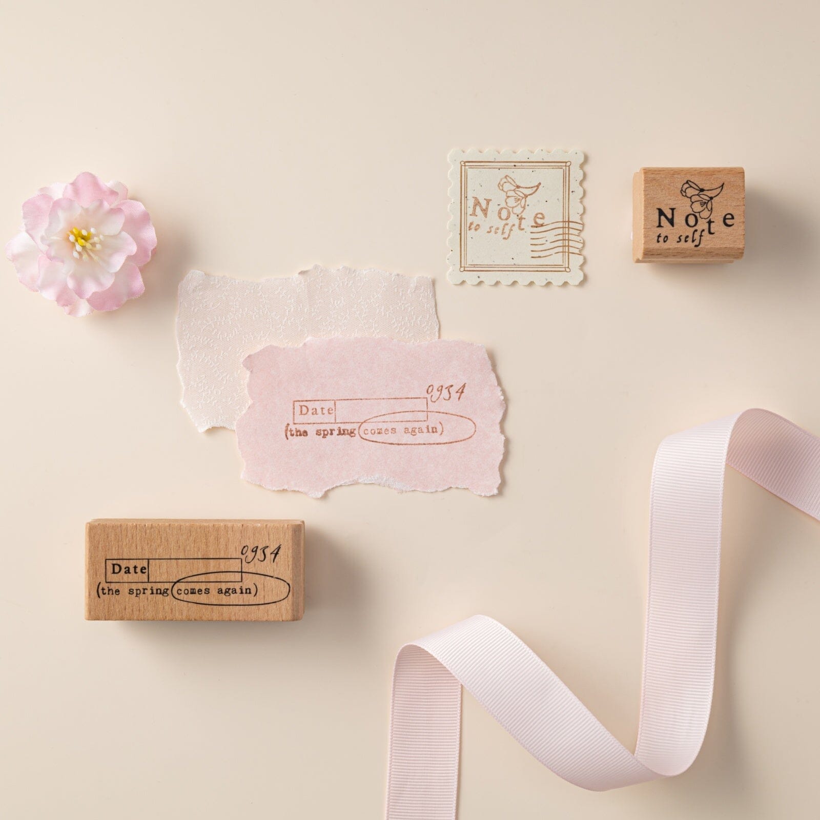 The spring comes again text on wooden stamp stamped on pink paper