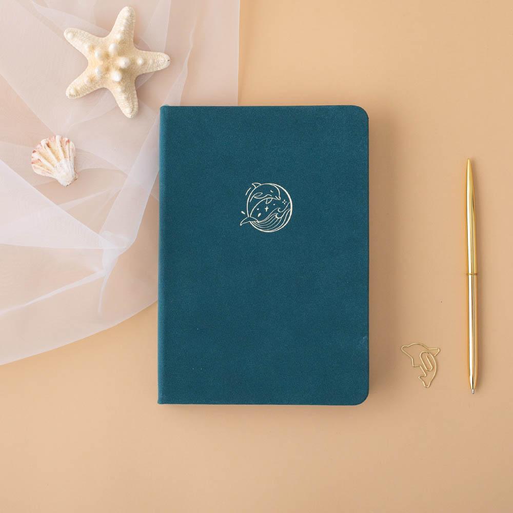 Tsuki sea green velvet Dolphin Days notebook with starfish and gold pen on peach background