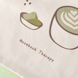 Close up of Tsuki ‘Matcha Matcha’ Tote Bag matcha design with Notebook Therapy logo on matcha green background
