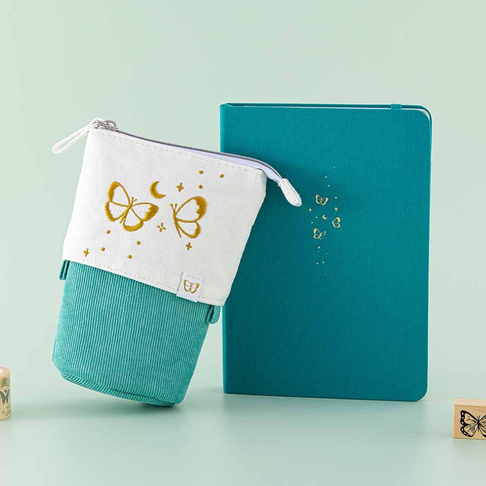 Tsuki ‘Flutter + Dream’ Pop-Up Pencil Case by Notebook Therapy x Pelinkan in teal with Tsuki Teal Sky ‘Flutter + Dream’ Limited Edition Bullet Journal by Notebook Therapy x Pelinkan with Tsuki ‘Flutter + Dream’ Bullet Journal Stamps by Notebook Therapy x Pelinkan in mint background