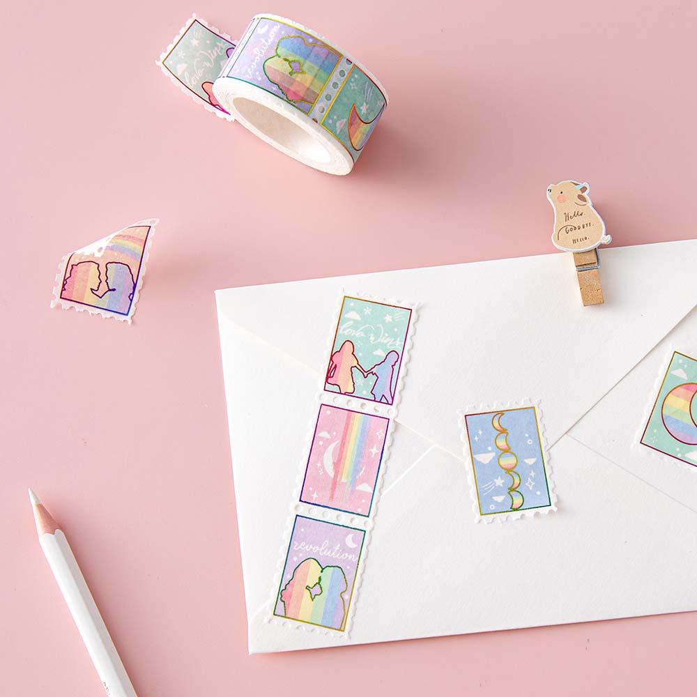 Tsuki Rainbow Pride Washi Tape on letter envelope with pencil and wooden bear peg on light pink background