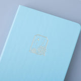 Close up of the front cover of Tsuki Endless Summer Limited Edition Bullet Journal in Petal Blue on light blue background