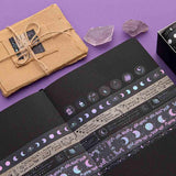 Tsuki ‘Moonlit Spell’ Washi Tape Set on open Tsuki ‘Moonlit Spell’ Limited Edition black page Holographic Bullet Journal with scrapbook paper parcel with amethyst stones on purple background