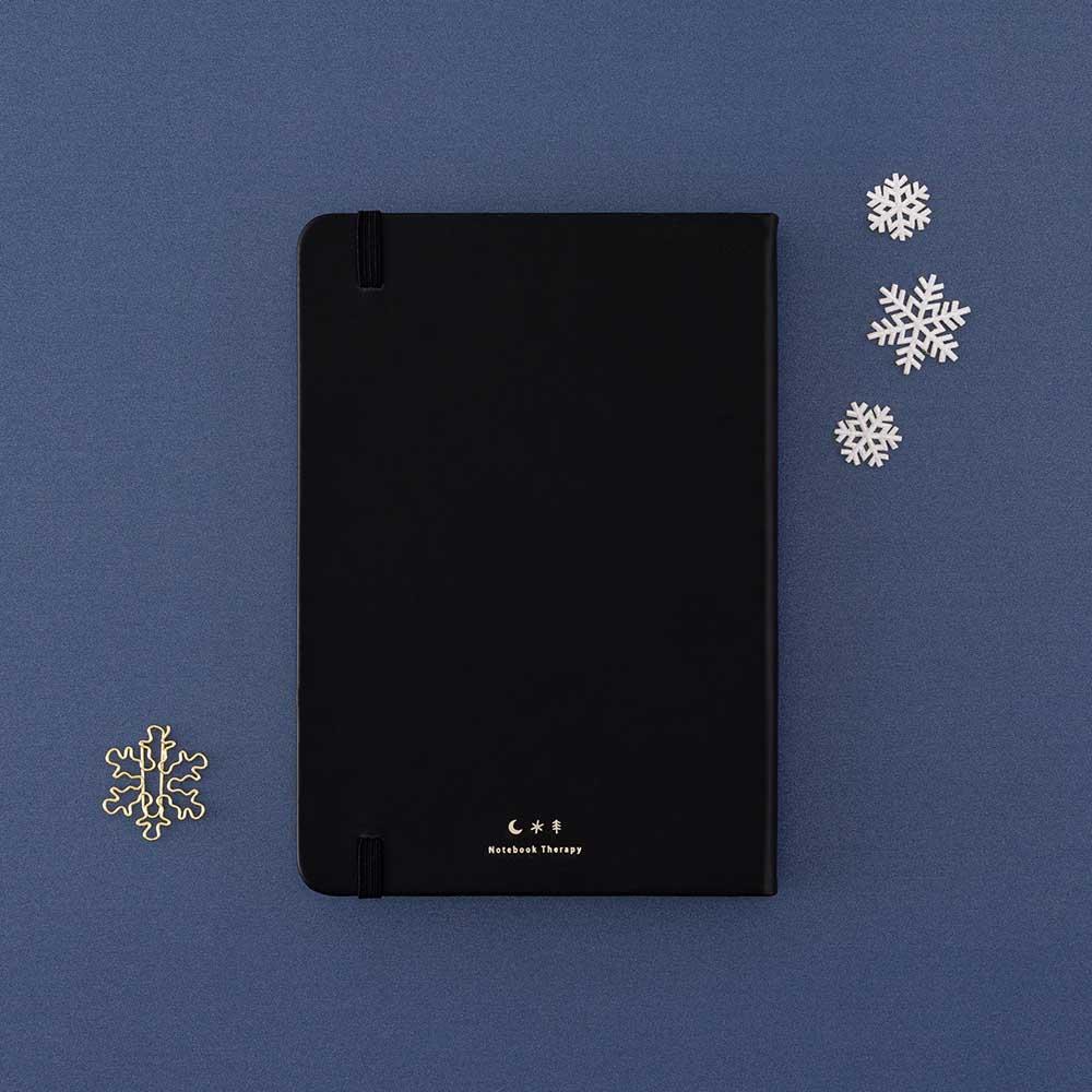 Back cover of Tsuki ‘Winter Journey’ Limited Edition Bullet Journal with free paperclip gift on navy background