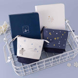 Tsuki ‘Dreams of Snow’ Pop-Up Pencil Cases in Starry Night and Playful Penguin with Tsuki ‘Suzume’ Winter Limited Edition Bullet Journal and Tsuki ‘Winter Wishes’ Limited Edition Bullet Journal in white basket with white flowers and snowflakes on light blue background