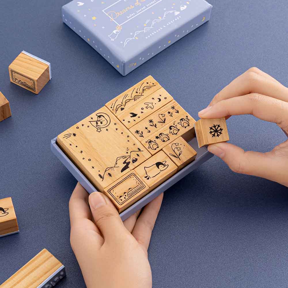 Tsuki ‘Dreams of Snow’ Bullet Journal Stamp Set held in hands in navy background