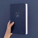 Tsuki ‘Winter Wishes’ Limited Edition Bullet Journal held in hand in navy background