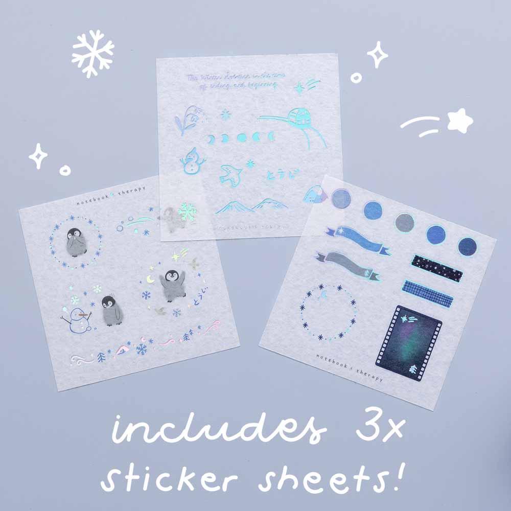 Three free stickers sheets from Tsuki ‘Dreams of Snow’ Holographic Washi Tape Set on light blue background