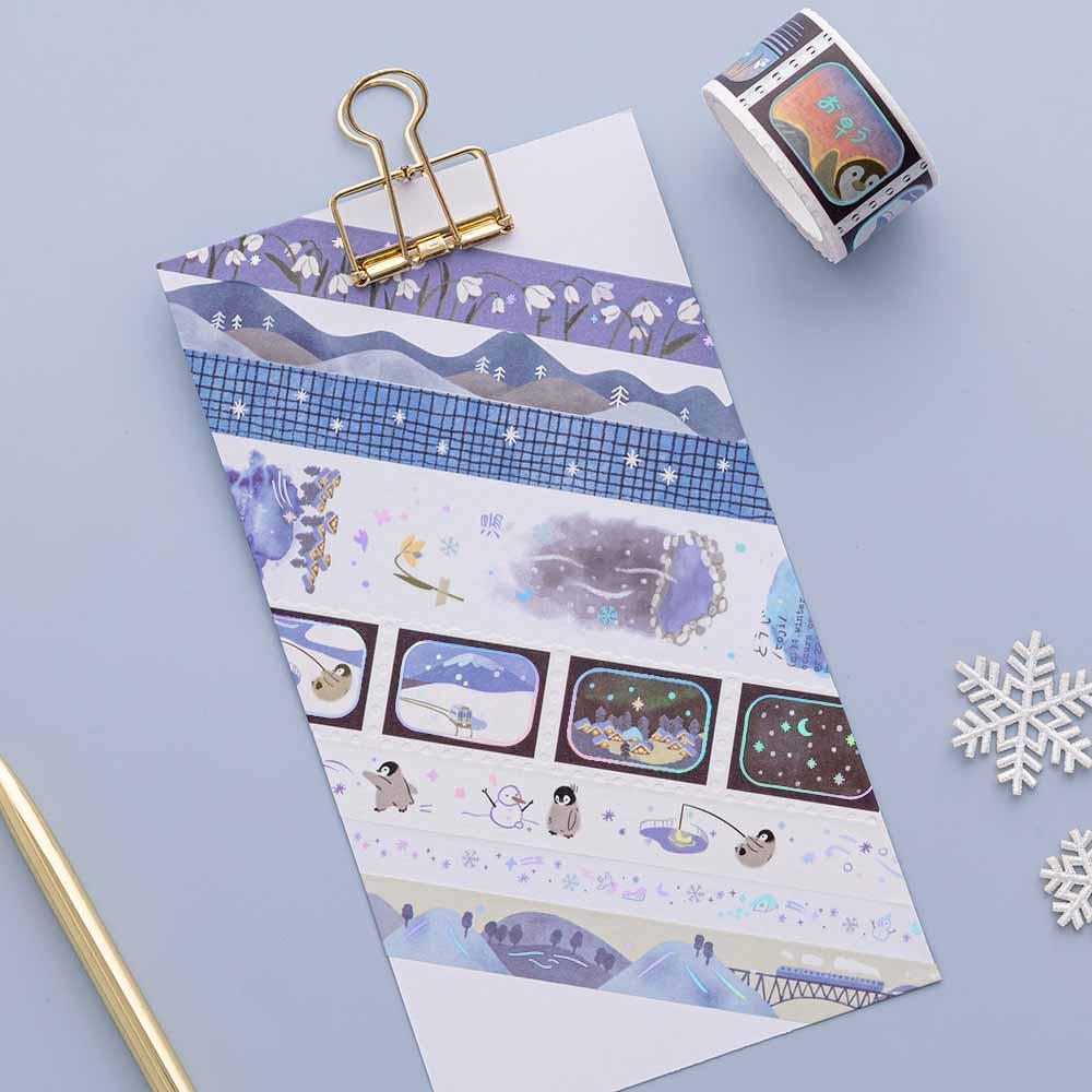 Tsuki ‘Dreams of Snow’ Holographic Washi Tapes on white card clipboard with snowflakes and gold pen on light blue background