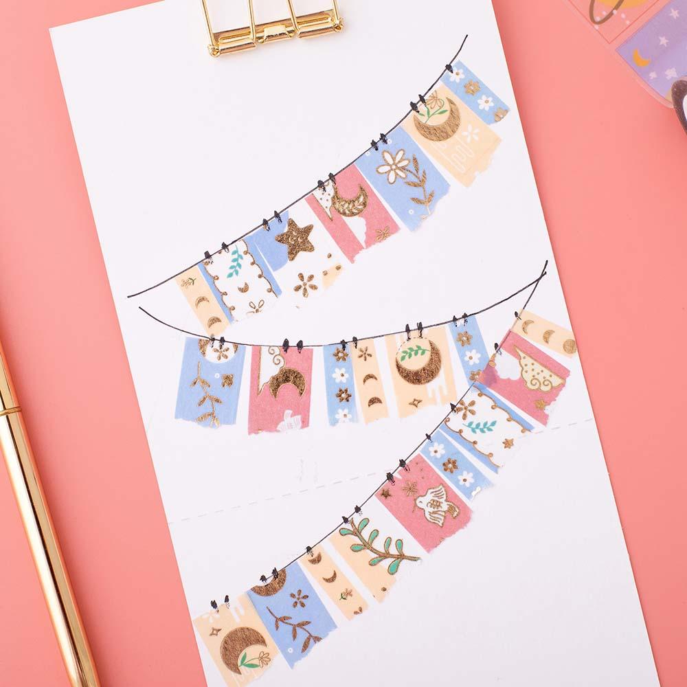 Tsuki ‘Moonflower’ Washi Tapes as bunting on white clipboard with pen on coral pink background