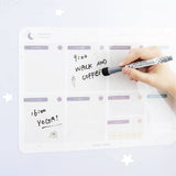 Tsuki Reusable Weekly with dry erase marker held in hands on smooth surface