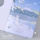 Close up of open front page of Tsuki Four Seasons Winter Collector’s Edition Bullet Journal with beautiful illustrations on light blue background 