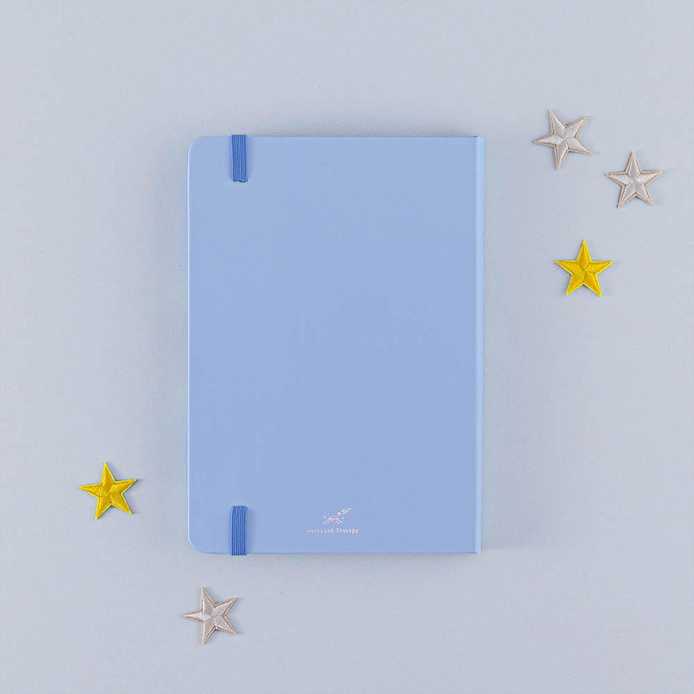 Back cover of Tsuki Four Seasons Winter Collector’s Edition Bullet Journal with stars on light blue background
