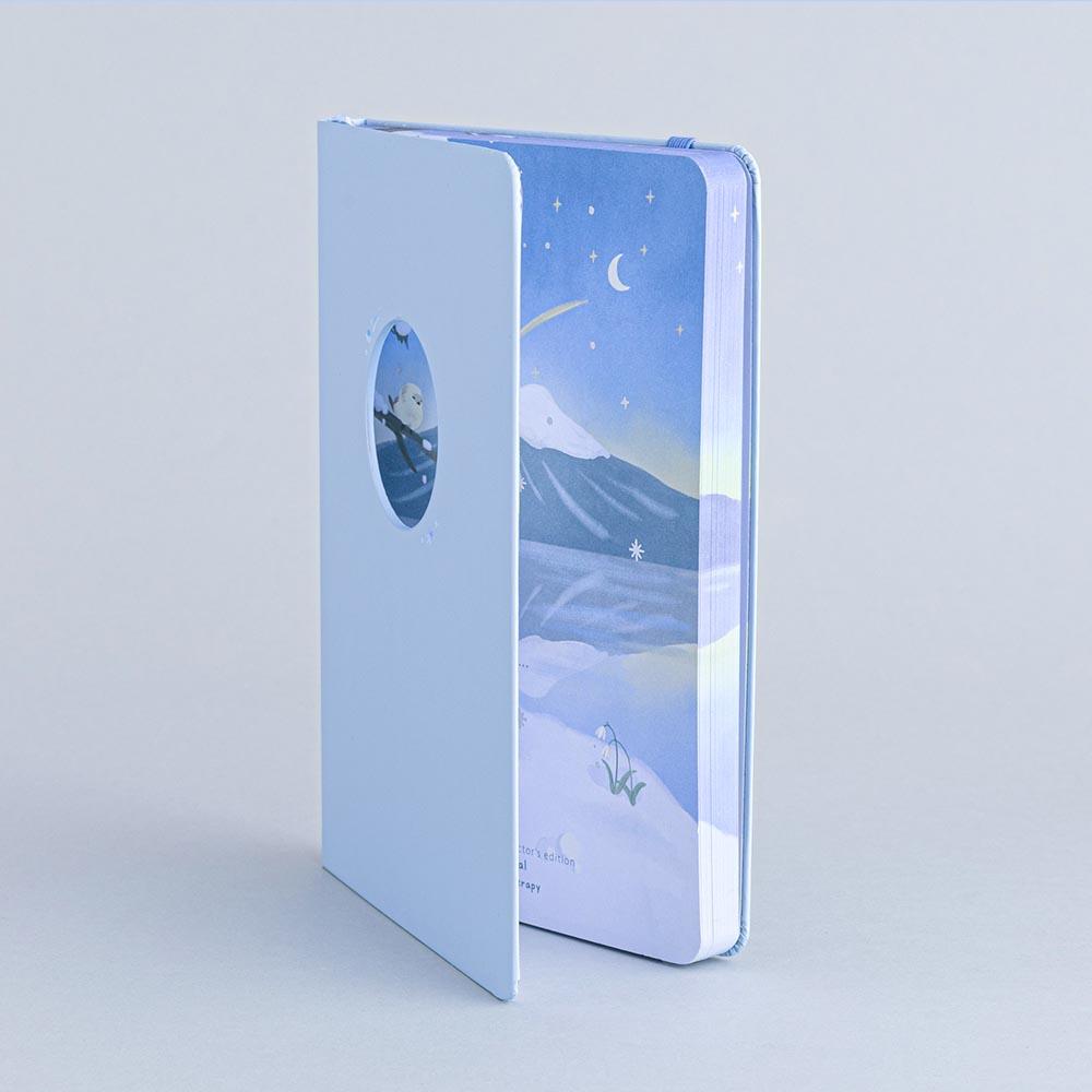 Tsuki Four Seasons Winter Collector’s Edition Bullet Journa at an angle in light blue background