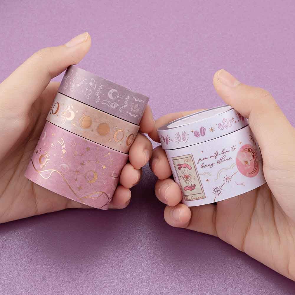 Close up of Tsuki ‘Moonlit Blush’ Washi Tape Set held in hands in purple background
