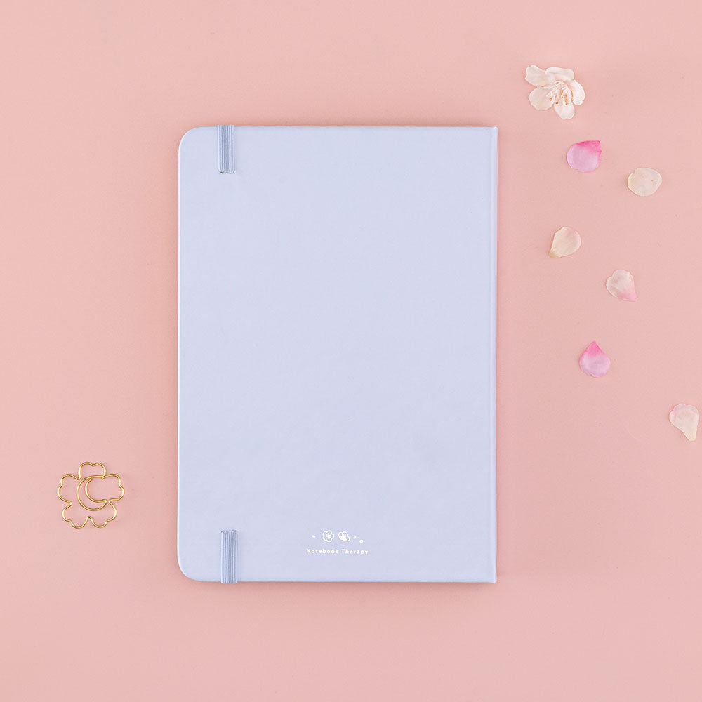 Back cover of Tsuki ‘Sakura Journey’ Limited Edition Bullet Journal with free bookmark gift with cherry blossom petals on pink background