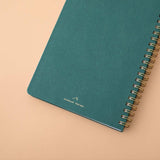 Close up of the back cover of Tsuki Ocean Edition Ring Bound notebook in deep teal on peach background