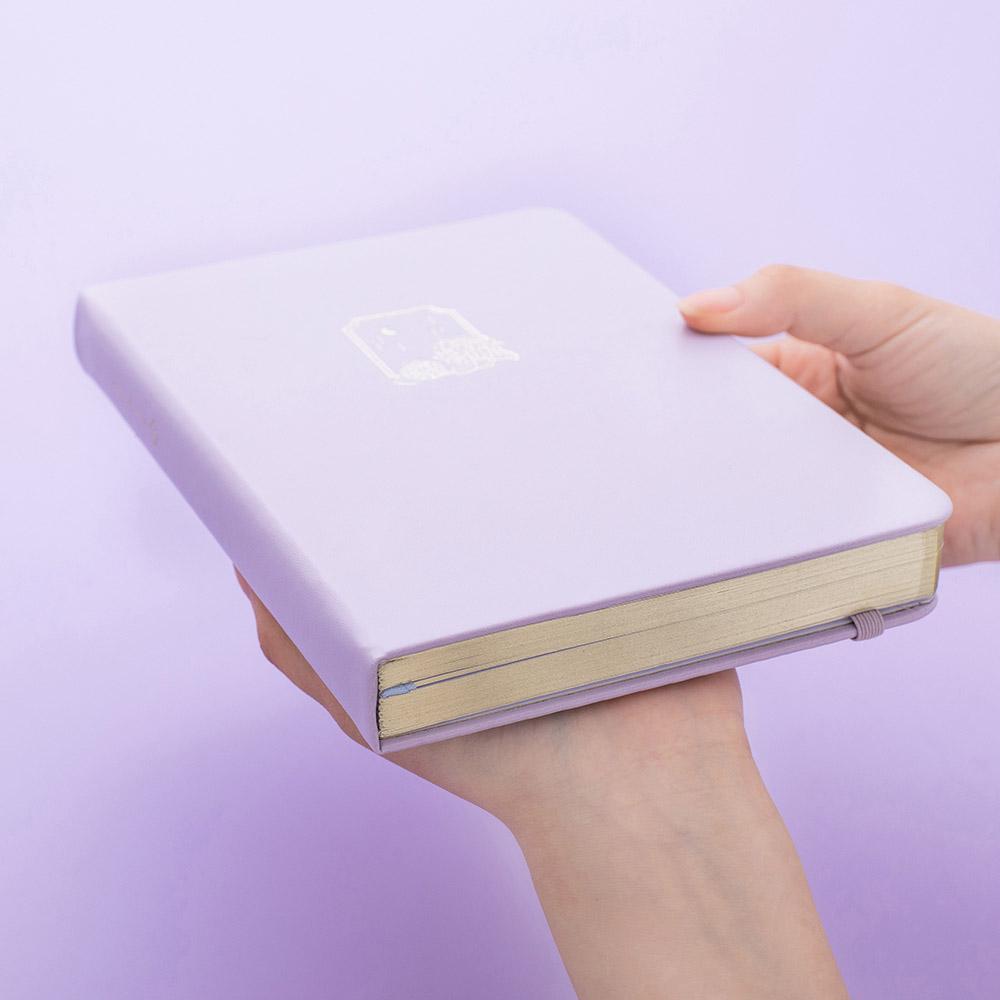 Tsuki Endless Summer Limited Edition Bullet Journal in Lilac Bloom held in hands at an angle in lilac background